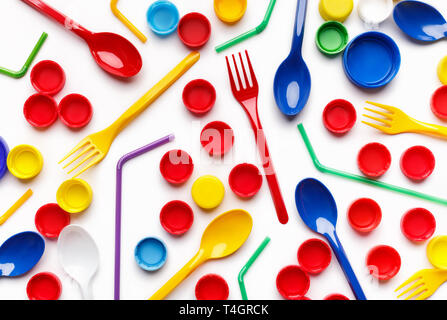 Colore uso singola di plastica e altri oggetti in plastica su sfondo bianco, vista dall'alto. Immondizia di plastica concetto sfondo Foto Stock