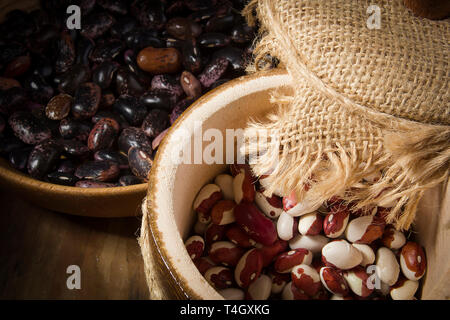 I fagioli in un piatto di legno sul tavolo Foto Stock