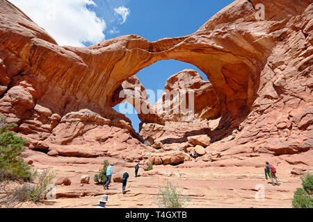 Visitatori escursione il sentiero di sabbia per salire la soggezione ispiratore per il doppio arco a Gli Archi Nazione Park in Utah, Stati Uniti d'America. Foto Stock