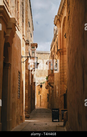 MDINA, MALTA - SETTEMBRE, 15 2018: Giallo strette strade medievali con tipico balcone maltese in Mdina, antica capitale di Malta, fortificata medievale Foto Stock