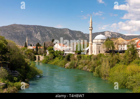 Mostar, Bosnia e Erzegovina - Aprile 2017: Nerteva fiume e la città vecchia di Mostar con moschea ottomana Foto Stock