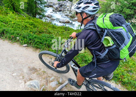 Mountainbiker moto dello sterzo su single trail Foto Stock