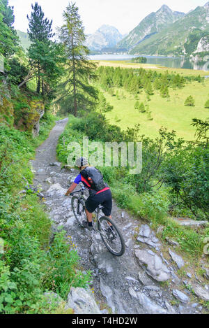 Mountainbiker moto dello sterzo su single trail Foto Stock