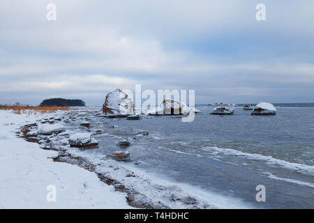 Massi ricoperti di neve lungo il Mar Baltico a riva, Estonia. Gelo invernale. Foto Stock