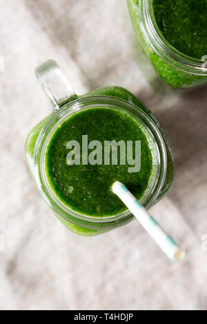 Vasi di vetro piena di verde smoothie con spinaci, avocado e banana, vista dall'alto. Piatto, laici overhead, dall'alto. Close-up. Foto Stock