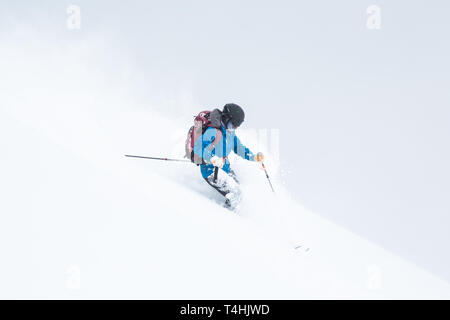 Sci backcountry di Hokkaido, Giappone, un giovane uomo è coperto di neve da sci il deep soft in polvere. Foto Stock