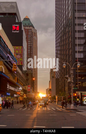 La città di New York, Stati Uniti d'America - 7 Giugno 2017: Manhattanhenge in New York. Sun impostazione tra edifici. Le persone che attraversano le street in strisce pedonali durante Manhatta Foto Stock