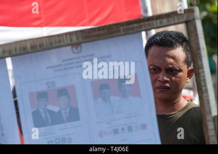 Jakarta, Indonesia. Xvii Apr, 2019. Un elettore controlla i candidati" informazioni in corrispondenza di una stazione di polling in Jakarta, Indonesia, 17 aprile 2019. Gli elettori in Indonesia ha iniziato a votare il mercoledì come stazioni di polling aperto nella parte orientale del vasto paese-arcipelago per selezionare un nuovo presidente e membri del parlamento. Credit: Veri Sanovri/Xinhua/Alamy Live News Foto Stock