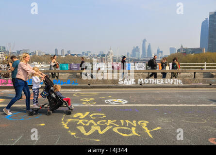 Londra, Regno Unito. Xvii Apr, 2019. I pedoni a piedi sul ponte di Waterloo coperto di graffiti di messaggi al giorno 3 della ribellione di estinzione protesta come parte di una protesta in corso per costringere il governo britannico a dichiarare una crisi climatica emergenza in 2 settimana di campagna Credito: amer ghazzal/Alamy Live News Foto Stock