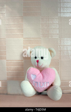 Un orsacchiotto di peluche con un cuore dicendo io amo mamma su di esso per la Festa della mamma Foto Stock