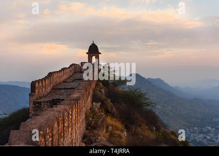 Antica parete lunga con torri intorno al Forte Amber al mattino. Jaipur. Il Rajasthan. India Foto Stock