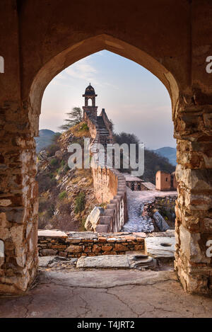 Antica parete lunga con torri intorno al Forte Amber attraverso l'arco delle pareti della torre al mattino. Jaipur. Il Rajasthan. India Foto Stock