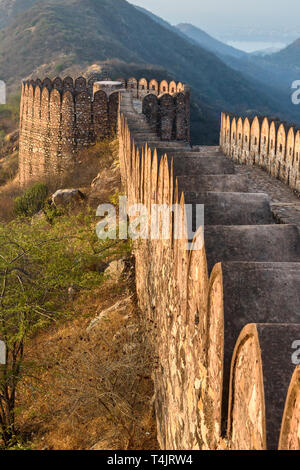 Antica parete lunga con torri intorno al Forte Amber al mattino. Jaipur. Il Rajasthan. India Foto Stock