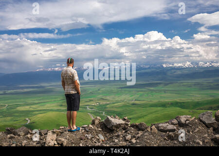 Un uomo è alla ricerca di una valle di montagna. Paesaggio di montagna. Il Kirghizistan. Valle Suusamyr. Too-Ashuu Pass Foto Stock