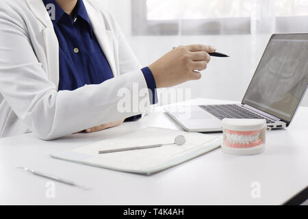 Dentista a lavorare in studio dentistico per spiegare il processo di trattamento di pazienza, medico di concetto di salute Foto Stock