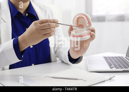 Dentista a lavorare in studio dentistico per spiegare il processo di trattamento di pazienza, medico di concetto di salute Foto Stock