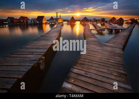 Tramonto sul lago Bokod con molo in legno e case galleggianti, Ungheria Foto Stock