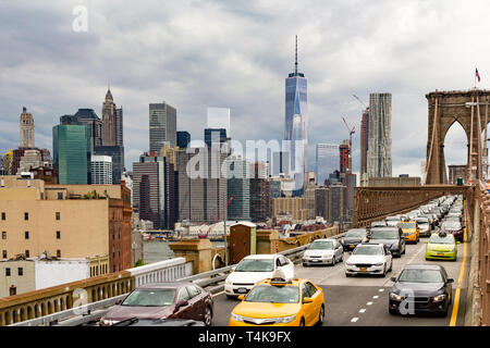 Pesanti flussi di traffico attraverso il ponte Brookyln voce fuori di Manhattan con la vista iconica del centro cittadino di Manhattan e i suoi grattacieli in background Foto Stock