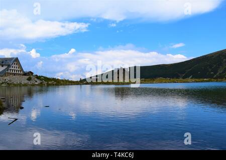 Un bellissimo paesaggio vicino al picco più alto nella penisola balcanica, Musala peak - una montagna con due cabine sullo sfondo e un lago di fronte a loro Foto Stock