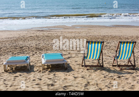 Vuoto due sedie a sdraio e sedie a sdraio pronto per noleggiare sulla spiaggia a Bournemouth Dorset Regno Unito nel mese di aprile Foto Stock