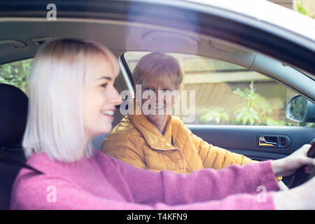 Prossimo femmina dando Senior donna un ascensore in auto Foto Stock