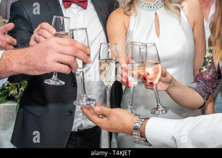 Cheers! Sposa e lo sposo e gli invitati a nozze la tostatura con champagne mentre avente party di nozze. Foto Stock