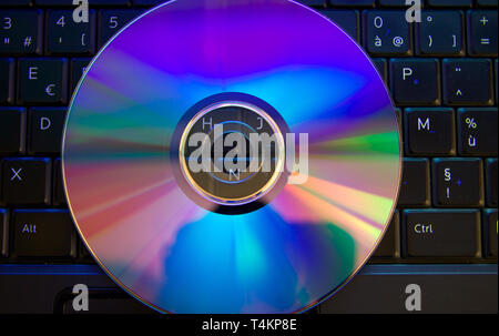 Rainbow dal disco compatto seduto sulla parte superiore di una illuminazione della tastiera del computer Foto Stock