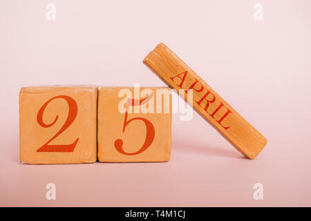 Aprile 25th. Giorno 25 del mese, fatta a mano in legno calendario cubo su moderni colori dello sfondo. molla mese, giorno dell'anno concetto. Foto Stock