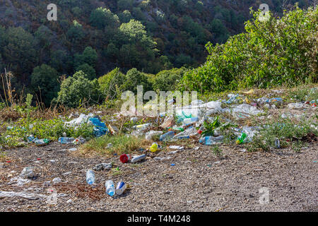 Bottiglie di plastica e altri rifiuti lungo la strada di montagna in Macedonia. Un sacco di immondizia in strada. Concetto di inquinamento ambientale Foto Stock