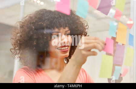 Creative African business donna il brainstorming con colorati sticky notes Foto Stock