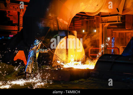 Duisburg, la zona della Ruhr, Renania settentrionale-Vestfalia, Germania - ThyssenKrupp Steel, un lavoratore di acciaio in una tuta protettiva richiede un grado 1500 hot ghisa campione Foto Stock