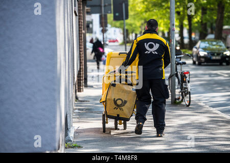 Postbote in der Großstadt zu Fuss unterwegs. Foto Stock