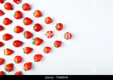 Fragola su sfondo bianco, vista dall'alto. Modello di frutti di bosco. Fragole fresche isolati su sfondo bianco. Cucina creativa del concetto. Appartamento laici, spazio di copia Foto Stock