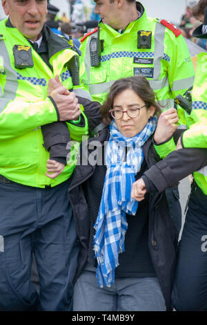 16 Aprile 2019: Eccitazione ribellione: Protester getting portano lontano in manette da una Met funzionario di polizia sul ponte di Waterloo, London.UK Foto Stock