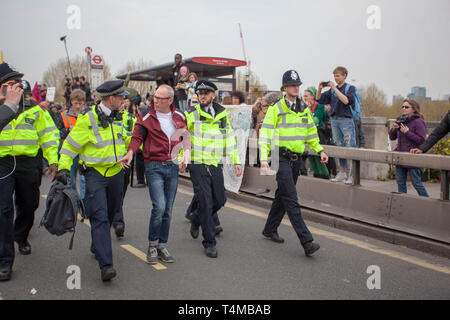 16 Aprile 2019: Eccitazione ribellione: Protester getting portano lontano in manette da una Met funzionario di polizia sul ponte di Waterloo, London.UK Foto Stock