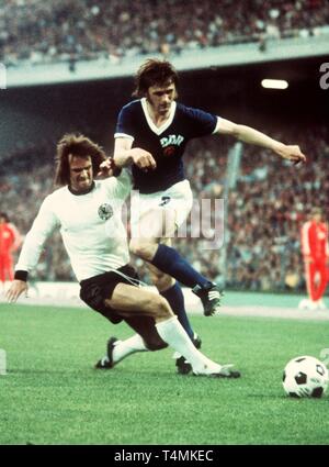 West centrocampista tedesco Wolfgang Overath (L) lotte con tedesco orientale defender Juergen Kurbjuweit per la palla durante il 1974 World Cup Soccer Game in Amburgo, Germania Ovest, 22 giugno 1974. La Germania est vince la partita contro la Germania ovest da un punteggio di 1-0. | Utilizzo di tutto il mondo Foto Stock