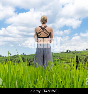 Rilassato e informale donna sportivo godendo di natura pura in splendidi e verdi risaie di Bali. Foto Stock