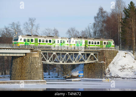 SAVONLINNA, Finlandia - 03 Marzo 2018: il treno locale sul ponte ferroviario nel soleggiato marzo pomeriggio Foto Stock