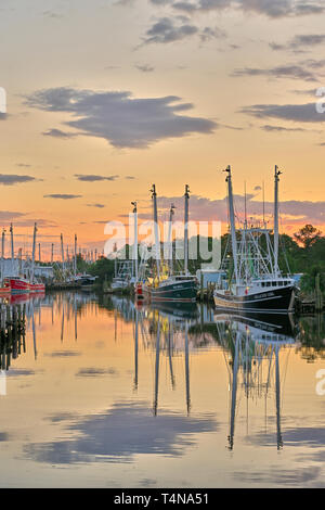 La pesca commerciale di imbarcazioni e natanti adibiti alla pesca di gamberetti legato fino al tramonto in Bayou La Batre Alabama, Stati Uniti d'America. Foto Stock