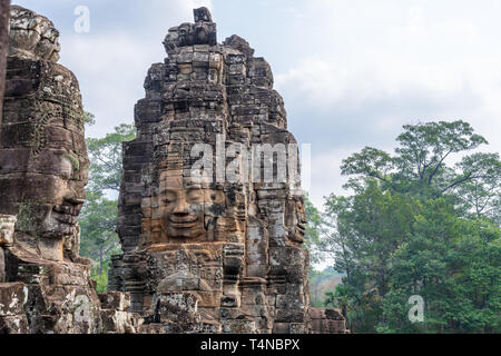 Giant volti umani su torri del tempio Bayon, parte di Angkor Wat parco archeologico di Siem Reap, Cambogia Foto Stock