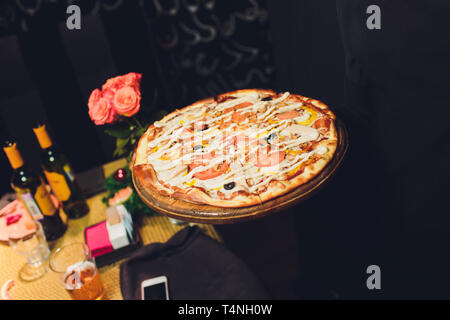 Vista dall'alto una gustosa pizza italiana su sfondo scuro. Foto Stock