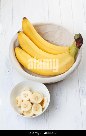 Fette di banana nella ciotola sul tavolo di legno Foto Stock