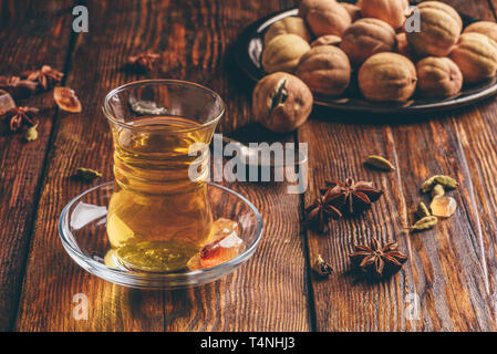 Tè orientali con anice stellato, cardamomo e essiccato in calce armudu vetro sopra una superficie di legno Foto Stock