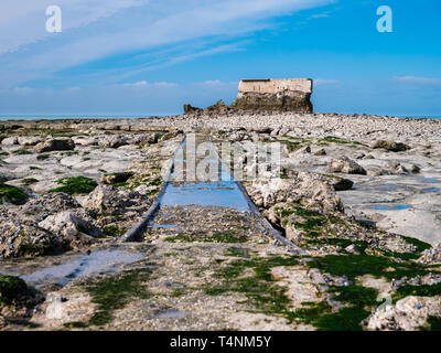 Antica railtracks che conduce attraverso le rocce di una fortezza abbandonata sul litorale Foto Stock