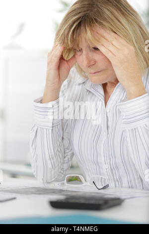 Imprenditrice che soffrono di mal di testa seduto in ufficio Foto Stock