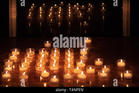Candele accese su un tavolo accanto a una finestra nel buio Foto Stock