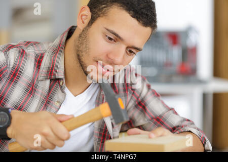 Uomo di costruire una casa e workimg con martello e legno Foto Stock