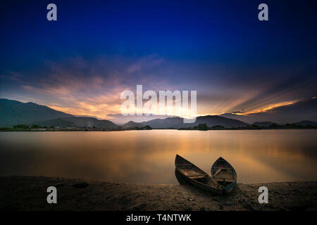 Bellissima alba presso la laguna con la barca il focus principale. Il concetto di sensazione di Solitario Foto Stock