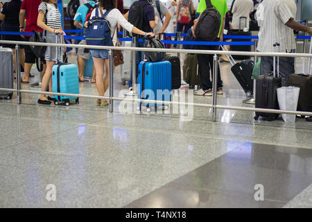 Vicino la coda di Asia i passeggeri in linea alla porta di imbarco in aeroporto Foto Stock