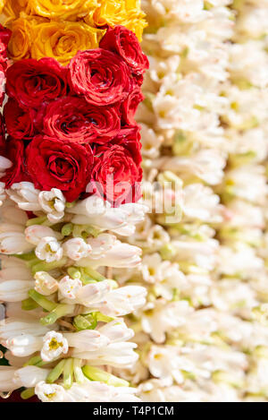 Vista verticale di ghirlande fatte di rose e gelsomino Mattuthavani al mercato dei fiori a Madurai, India. Foto Stock